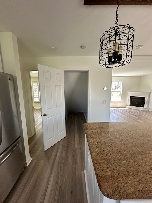 9615 Woodland Ct, Ypsilanti, MI 48197 - unfurnished dining area with dark wood-style flooring, a notable chandelier, and a fireplace