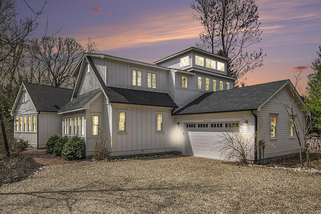 view of front of home with an attached garage, board and batten siding, roof with shingles, and driveway