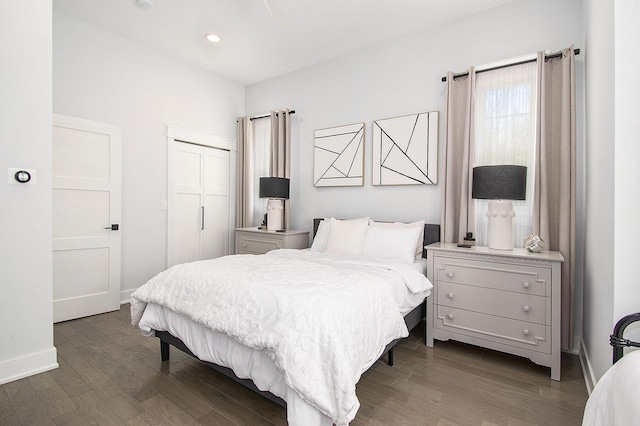 bedroom with recessed lighting, baseboards, dark wood-style floors, and a closet