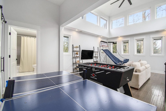 playroom featuring baseboards and a high ceiling