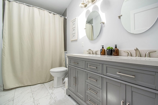 bathroom featuring double vanity, toilet, a sink, and marble finish floor