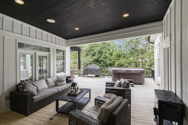 wooden terrace featuring a hot tub, outdoor lounge area, and grilling area
