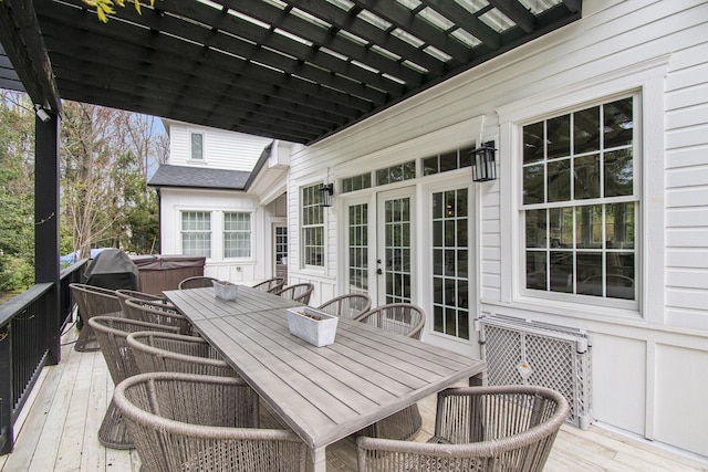 deck featuring a hot tub, french doors, and outdoor dining space