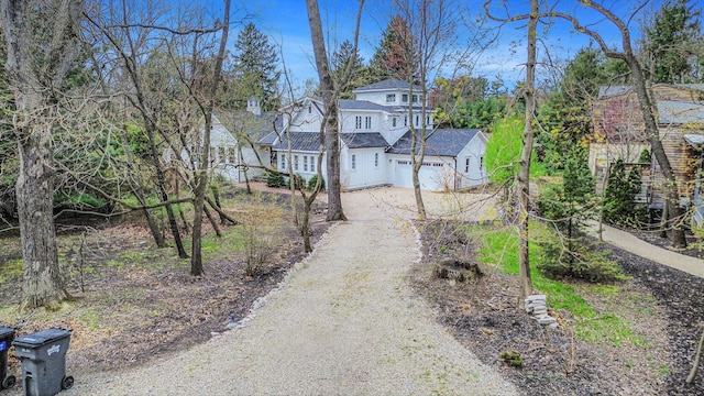 traditional-style home featuring a garage and dirt driveway