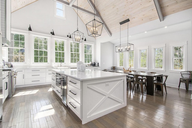 kitchen with light countertops, high vaulted ceiling, a chandelier, a center island, and high end range