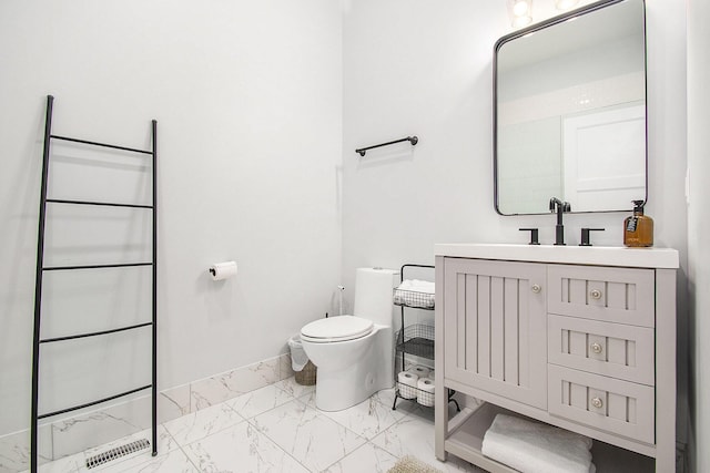 bathroom featuring toilet, baseboards, marble finish floor, and vanity