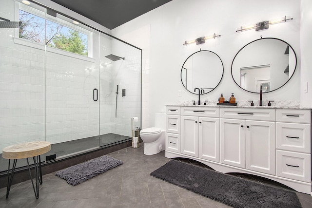 full bathroom with double vanity, a sink, a stall shower, and toilet