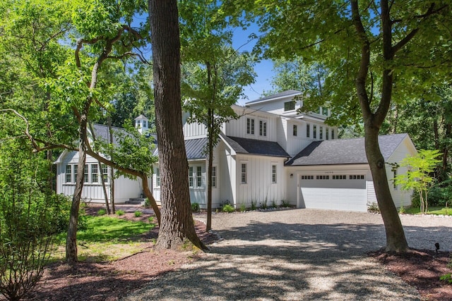 view of front facade featuring board and batten siding, an attached garage, and driveway