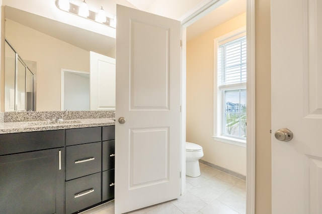 full bath featuring a stall shower, vanity, tile patterned floors, baseboards, and toilet