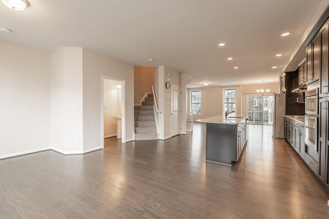 kitchen with light stone counters, recessed lighting, dark wood-style floors, and a chandelier
