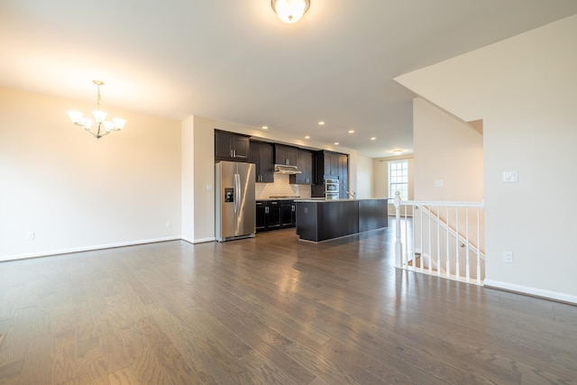 unfurnished living room with baseboards, recessed lighting, a chandelier, and dark wood-style floors