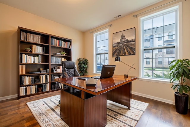 office space with visible vents, dark wood-style flooring, and baseboards