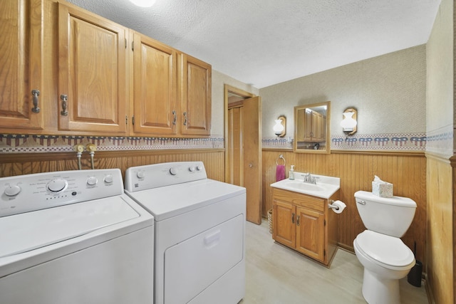 8577 Glenwood Ct, Jackson, MI 49201 - laundry room with washer and dryer, laundry area, a sink, a textured ceiling, and a wainscoted wall