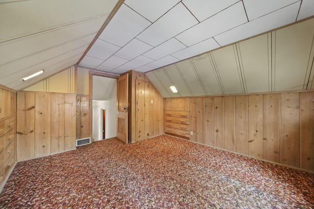 8577 Glenwood Ct, Jackson, MI 49201 - additional living space with visible vents, carpet, wooden walls, and vaulted ceiling