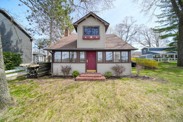 8577 Glenwood Ct, Jackson, MI 49201 - bungalow-style home featuring a front lawn, fence, roof with shingles, a chimney, and a sunroom