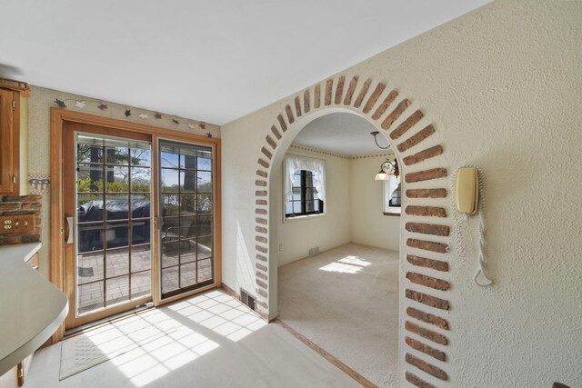 8577 Glenwood Ct, Jackson, MI 49201 - doorway to outside featuring arched walkways, carpet, and visible vents