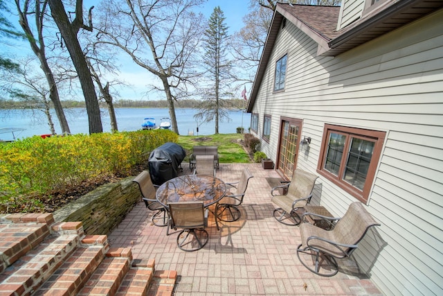 8577 Glenwood Ct, Jackson, MI 49201 - view of patio with outdoor dining space, a water view, and a grill