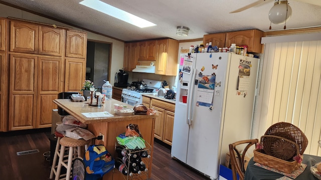 2513 Moore Dr, Allegan, MI 49010 - kitchen featuring white appliances, vaulted ceiling, dark wood-style flooring, exhaust hood, and brown cabinets