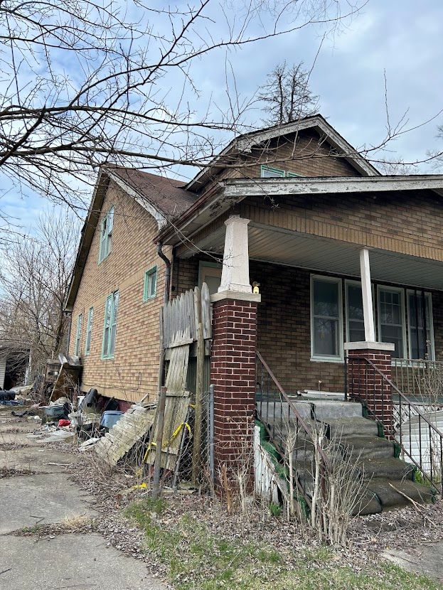 view of home's exterior with covered porch and brick siding