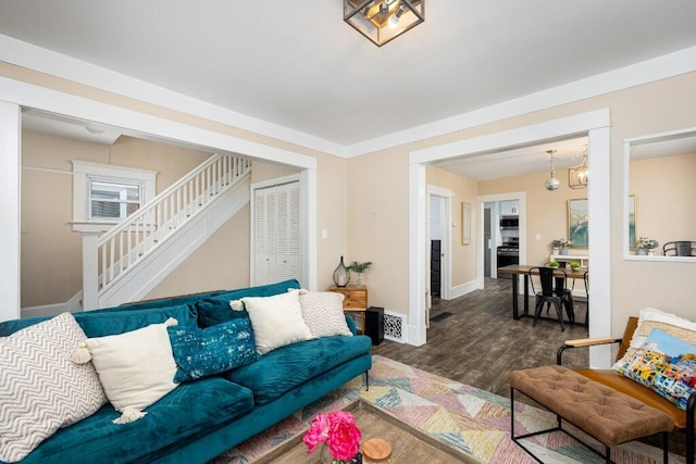 living area featuring stairway, baseboards, dark wood finished floors, and visible vents