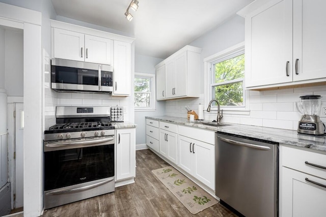 kitchen with plenty of natural light, a sink, appliances with stainless steel finishes, and tasteful backsplash