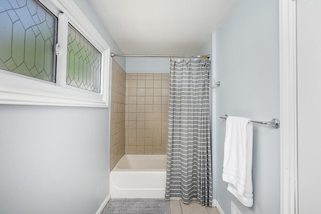bathroom featuring baseboards, shower / tub combo with curtain, and tile patterned flooring
