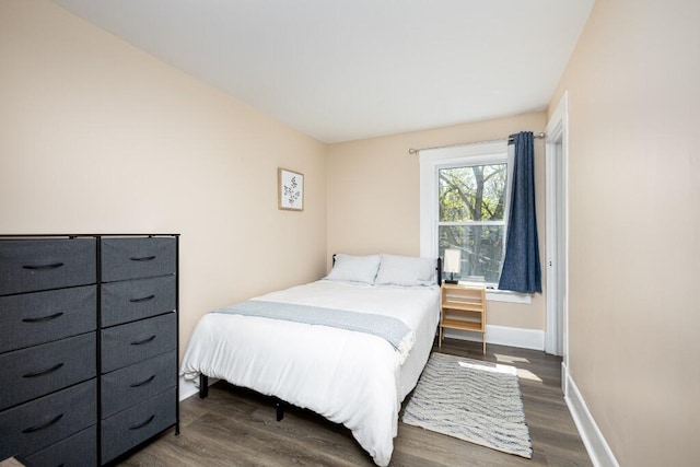 bedroom featuring baseboards and dark wood finished floors