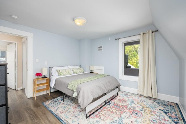 bedroom featuring access to outside, baseboards, vaulted ceiling, and wood finished floors