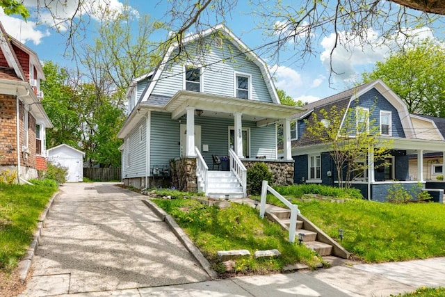 colonial inspired home featuring a garage, a gambrel roof, a front lawn, and covered porch