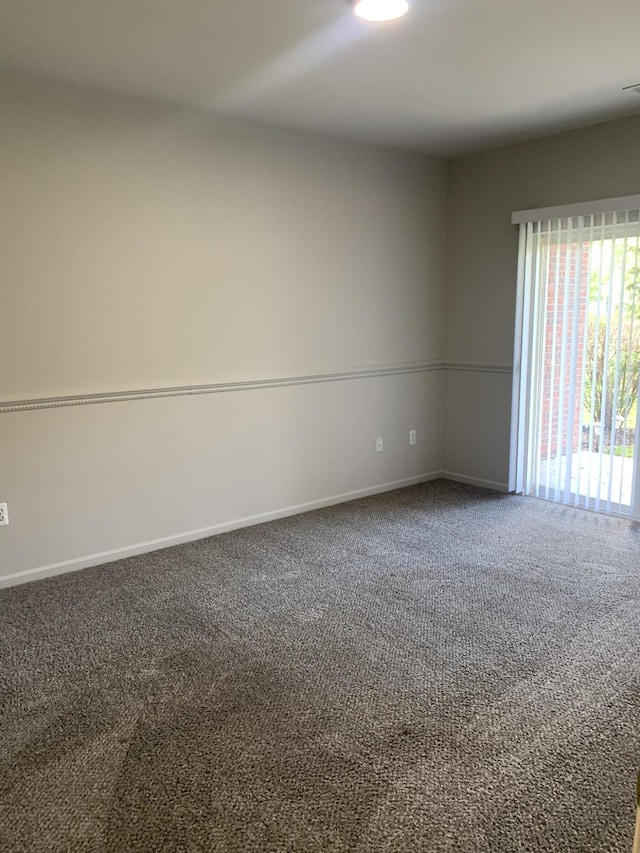 carpeted empty room with baseboards