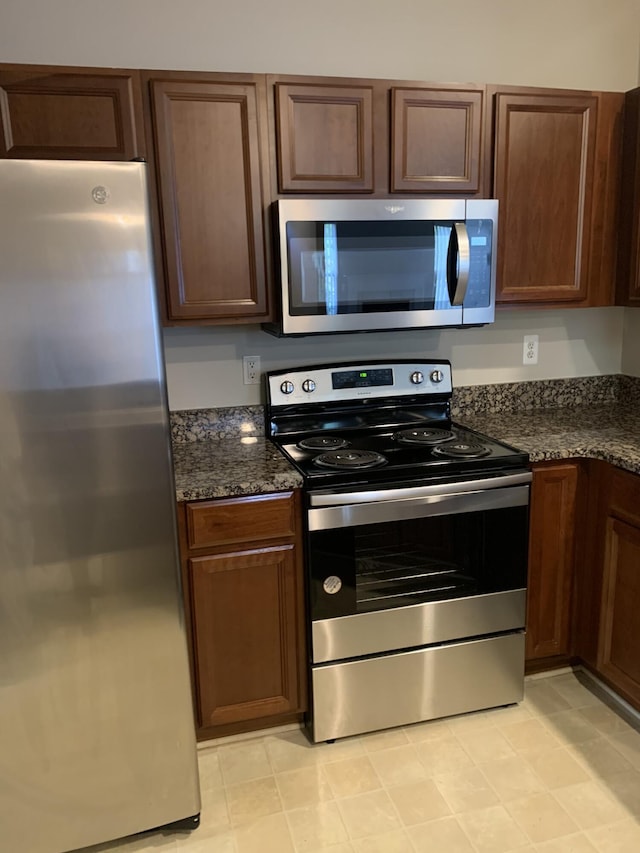 kitchen featuring appliances with stainless steel finishes and dark stone countertops