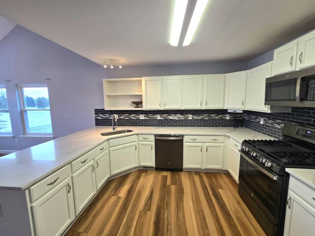 kitchen featuring open shelves, dishwasher, gas stove, stainless steel microwave, and a peninsula