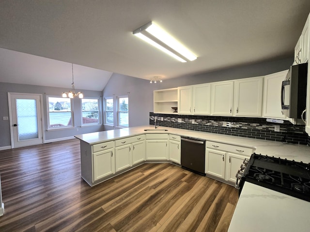 kitchen with a peninsula, dark wood-style floors, tasteful backsplash, a sink, and black appliances