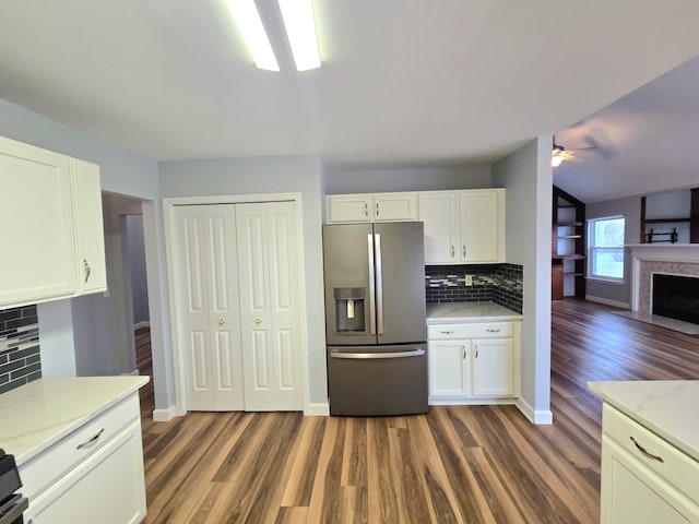 kitchen with white cabinets, dark wood-style flooring, ceiling fan, stainless steel fridge with ice dispenser, and decorative backsplash