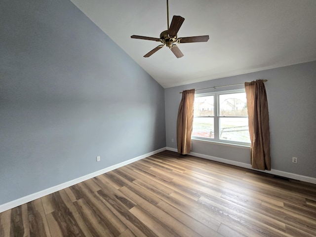 unfurnished room with visible vents, wood finished floors, baseboards, ceiling fan, and vaulted ceiling