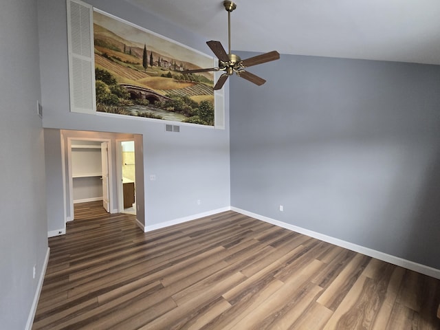 unfurnished room featuring ceiling fan, a towering ceiling, visible vents, wood finished floors, and baseboards