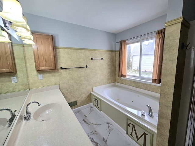 full bath featuring a whirlpool tub, visible vents, marble finish floor, and vanity