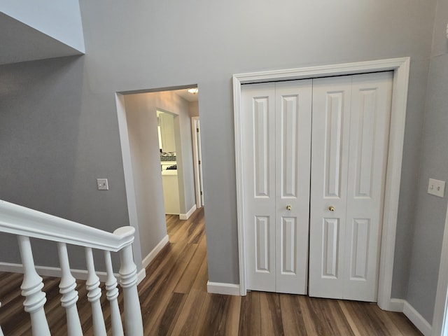 hallway with baseboards and dark wood-style floors