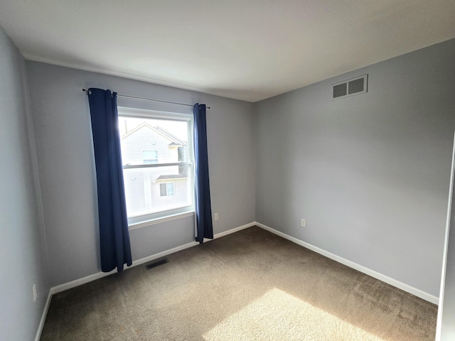 unfurnished room featuring dark carpet and baseboards