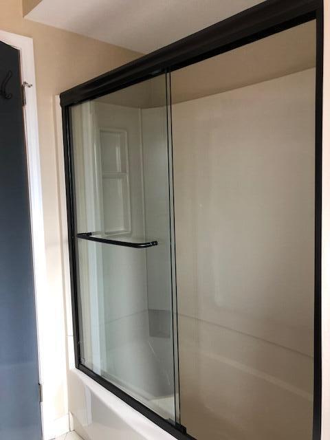full bath featuring combined bath / shower with glass door
