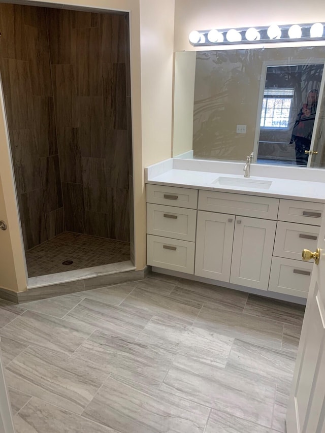 bathroom with vanity and a tile shower