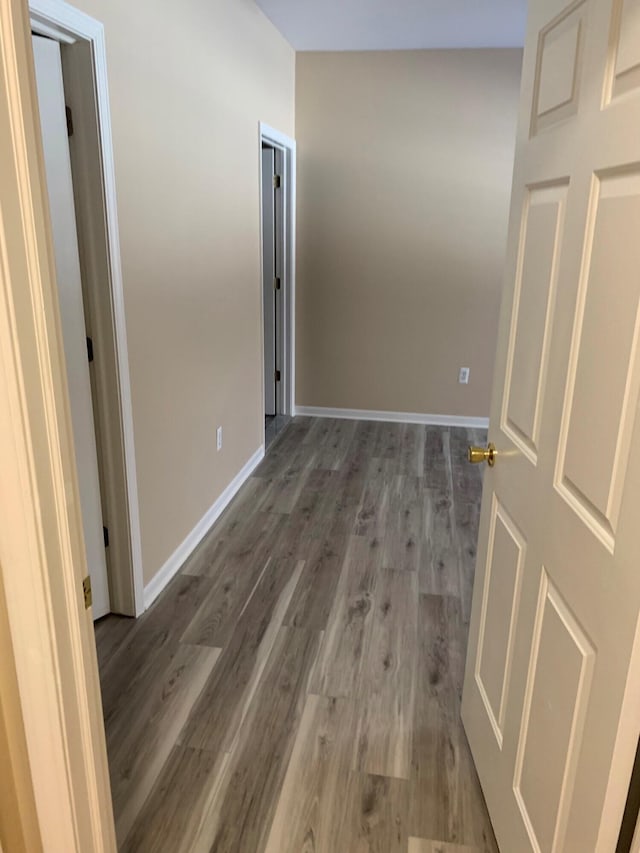 hall featuring baseboards and wood finished floors