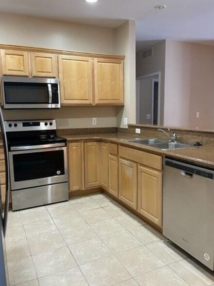 kitchen with light tile patterned floors, appliances with stainless steel finishes, a sink, and recessed lighting