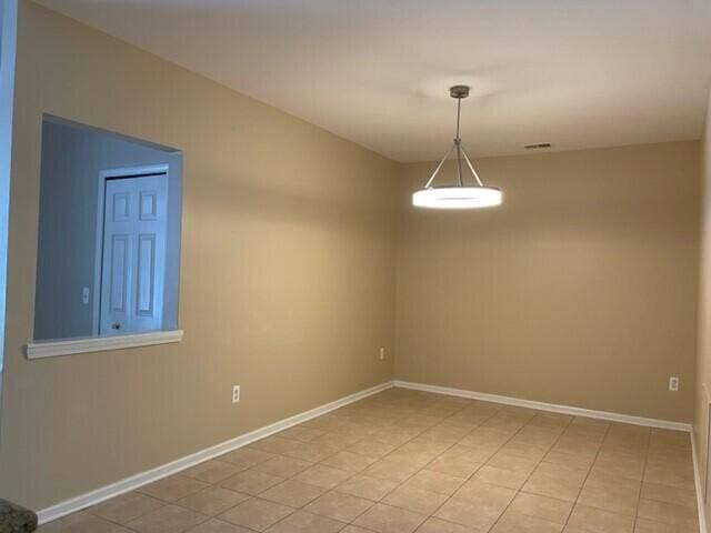 spare room featuring light tile patterned flooring, baseboards, and visible vents