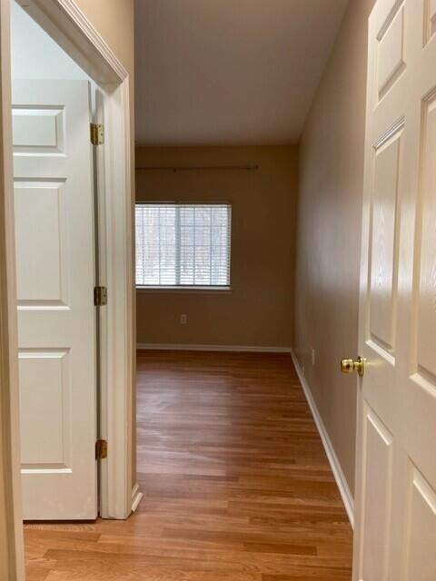 hall featuring baseboards and light wood-style flooring