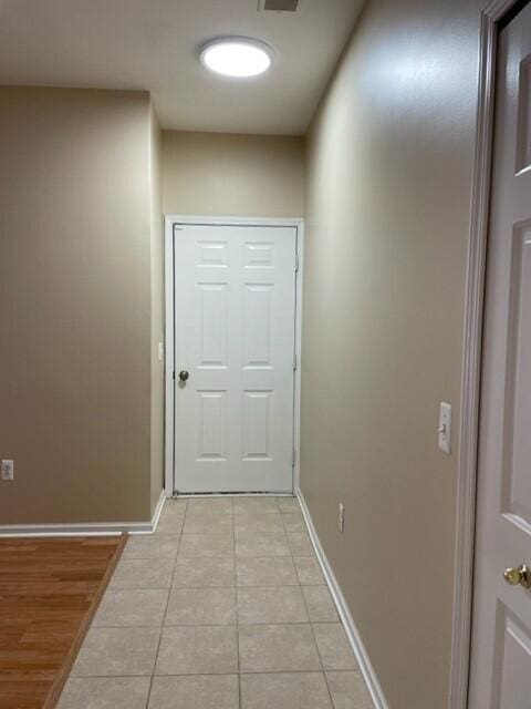 entryway with baseboards and light tile patterned floors