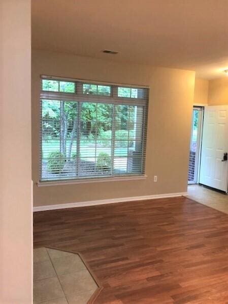 empty room featuring visible vents, light wood finished floors, and baseboards