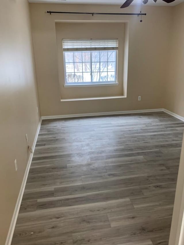 unfurnished room with baseboards, ceiling fan, and wood finished floors