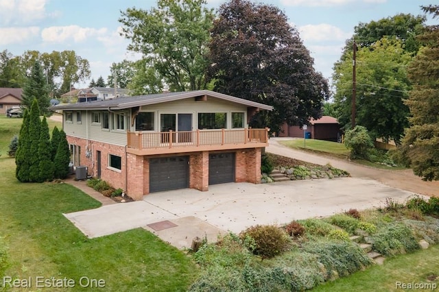 view of front of house featuring brick siding, a garage, driveway, and cooling unit