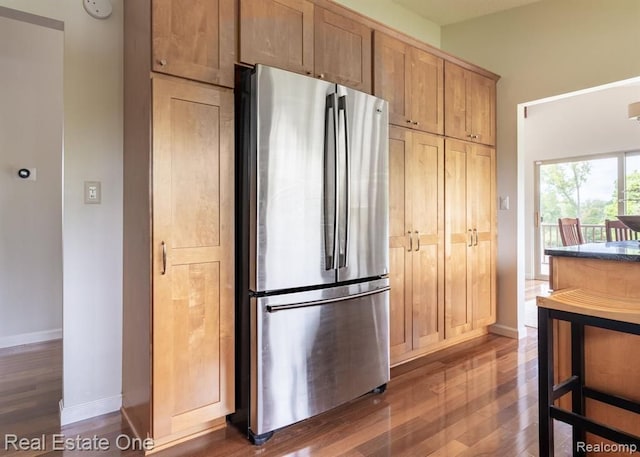 kitchen with baseboards, freestanding refrigerator, and wood finished floors